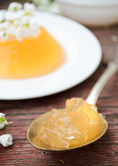 orange jelly with white flowers on wooden background