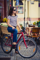 Fototapeta na wymiar Urban biking - young woman and bike in city