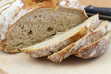 Rustic whole grain bread slices on wooden board
