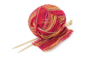 Ball of colorful yarn, wooden knitting needles, and a piece of hand knitted textile. Pure white background, soft shadows.