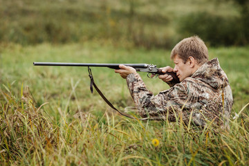 hunter in camouflage clothes ready to hunt with hunting rifle