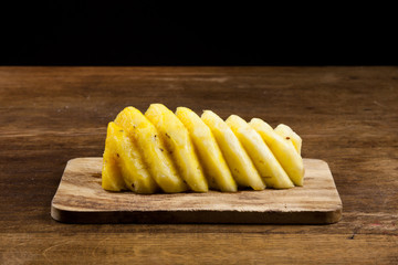 geschnittene Ananasfrucht auf einem Holzbrett