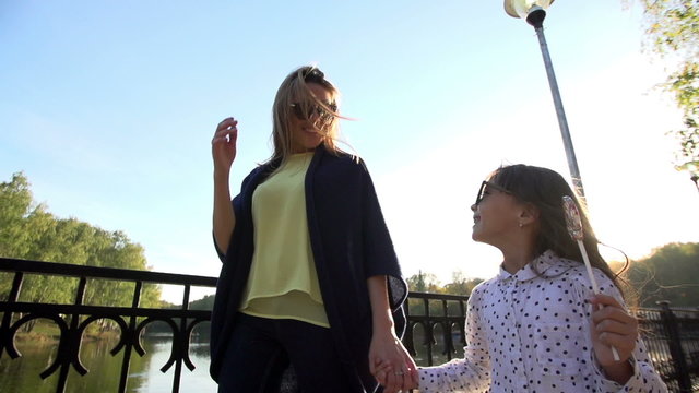 Mother and daughter walking in the Park holding hands
