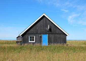 Fototapeta na wymiar Summer House with Black wooden planks and Blue Door