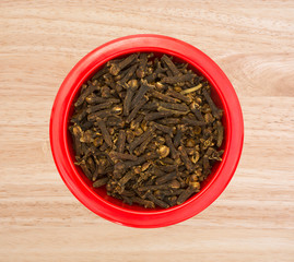 Whole cloves in a red dish on counter top view