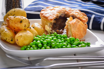 Meat pie with new potatoes and peas.