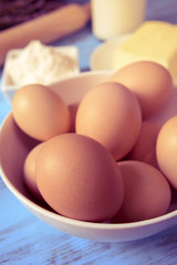 eggs, butter, flour and milk on a blue wooden table