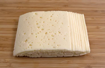 Foto auf Acrylglas Slices of Havarti cheese on a cutting board © Bert Folsom