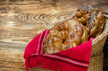 Shot of Eastern Europe traditional braided pretzels in a woven basket with a red traditional towel against wooden background