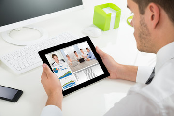 Businessman Videoconferencing With Colleagues On Digital Tablet