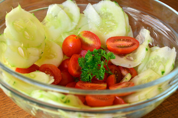 Healthy vegetable salad with cucumber and tomatoes in the glass bowl 