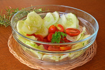 Healthy vegetable salad with cucumber and tomatoes in the glass bowl 