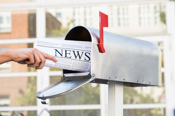 Person Hands Opening Mailbox To Remove Newspaper