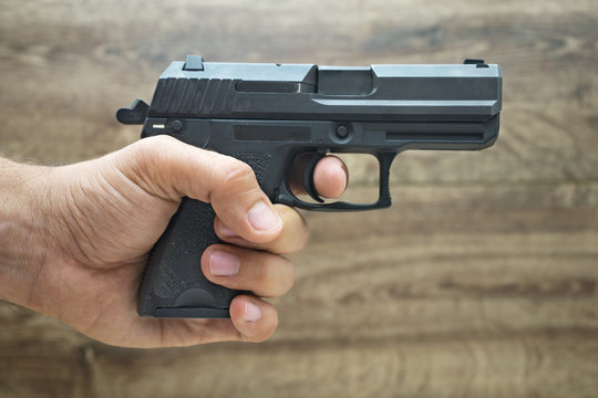 Μasculine hand holding pistol gun