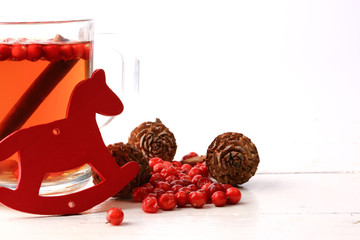 Christmas tea with cranberry Christmas decorations cones grog cider winter white wooden background...