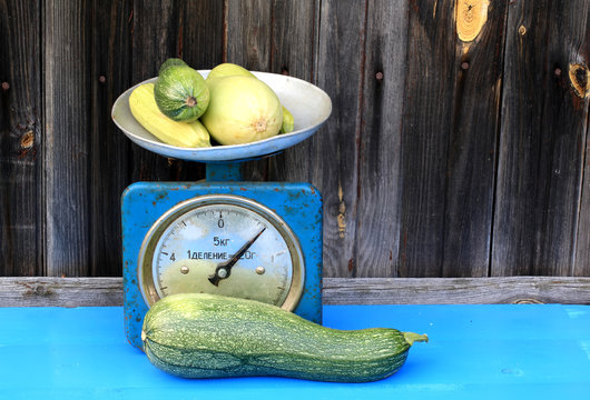 vintage scales courgettes on dark wooden background rustic farm products