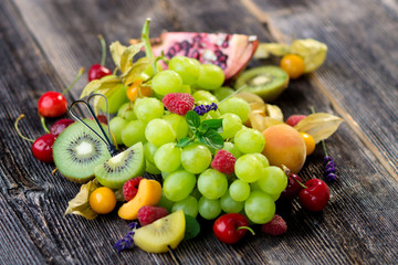 Delicious mixed fresh fruits on wooden background