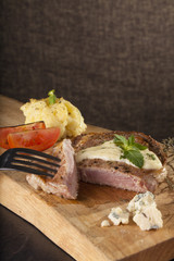 steak, a prepared piece of steak cut with blue cheese sauce on dining table decorated