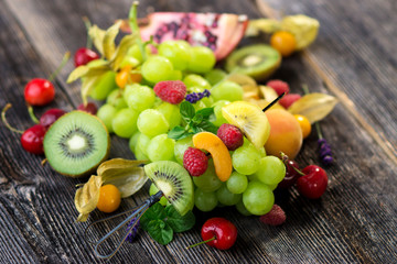 Delicious mixed fresh fruits on wooden background