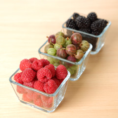 Raspberry, blackberry and gooseberry in glass cups