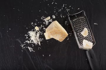 Fototapete grated cheese, grated parmesan cheese with a grater © akeeris