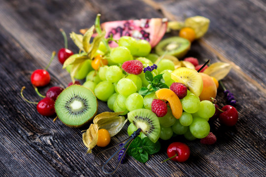 Delicious mixed fresh fruits on wooden background
