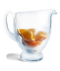 Slices of oranges in cooled pitcher isolated on white.