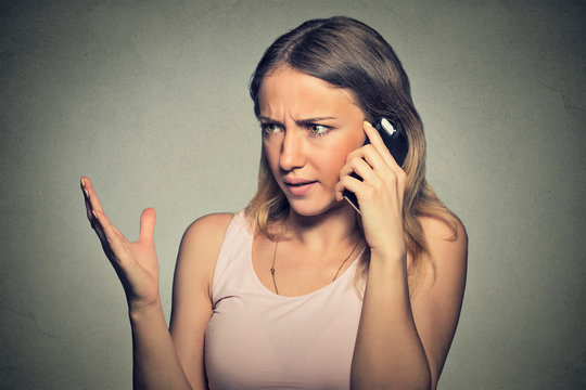 upset angry skeptical, unhappy, serious woman talking on mobile phone