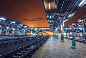 Fototapeta premium Stacja kolejowa w nocy. Peron pociągu we mgle. Popędzać