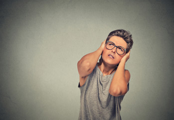 annoyed, unhappy, stressed woman covering her ears, looking up