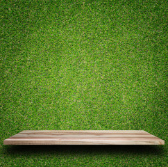 Empty top of wooden shelves and green pattern wall background