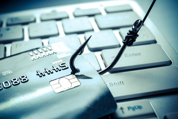 credit card phishing - piles of credit cards with a fish hook on computer keyboard - obrazy, fototapety, plakaty