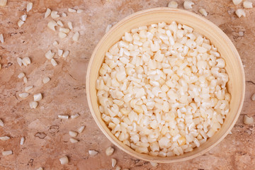 White grated corn kernels in wooden bowl