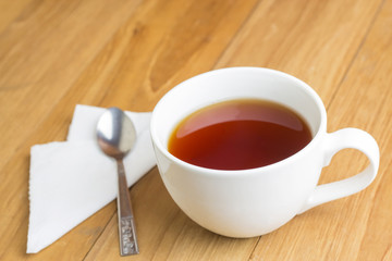 tea in mug and spoon on wooden board