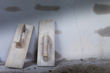 wood trowel and cement wall in construction site, trowel handhel