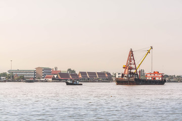 cargo crane ships over river in sunset