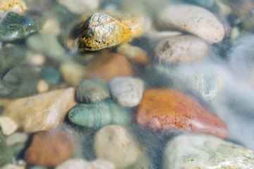 Pebble stones in the river water close up view,