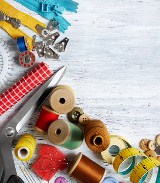 Overhead View Of Sewing Tools And Accessories On White Painted Wooden Background