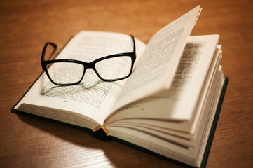 open book with glasses on top