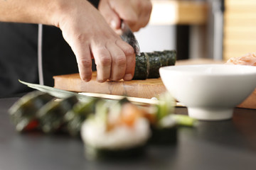 Sushi master przygotowuje sushi w japońskiej restauracji 