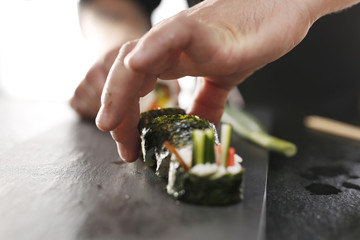 Sushi z łososiem, krewetką i ogórkiem. Klasyczne  grube rolki futomaki podane na kamiennym talerzu - obrazy, fototapety, plakaty