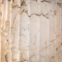 Black, grey, And white striated streaks In marble. Close up. Aged photo. Marble column Texture. Close-up structure of a Roman marble column.