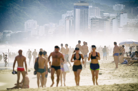 Busy crowded afternoon on Ipanema Beach during a misty sunset in Rio de Janeiro Brazil