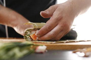 Zawijanie sushi. Zwijanie rolek sushi w bambusowej macie, etapy tworzenia. - obrazy, fototapety, plakaty
