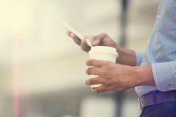 indian business man using phone and coffee in the morning