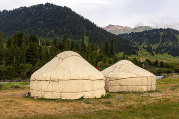 Yurts in Central Asian Veld
Two Traditional Mongol Nomad Housings assembled on Green Meadow among High Mountain Hills in Kyrgyzstan
