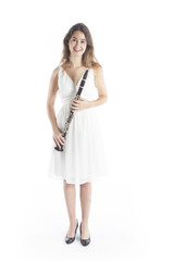 young brunette woman in white dress holds clarinet in studio and