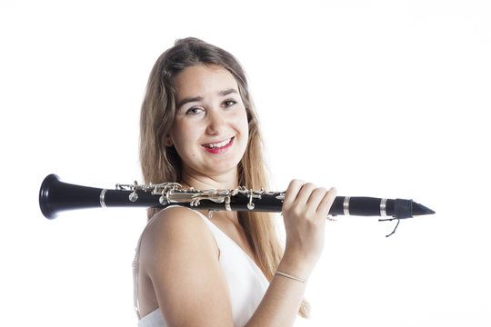young brunette woman holds clarinet on shoulder in studio and sm