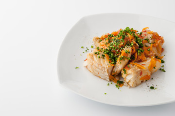 Cod with carrot and greens on the square ceramic plate