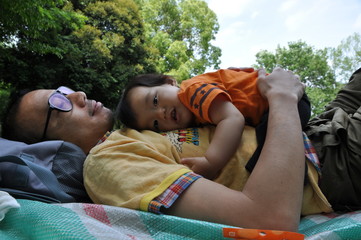 公園で寝転がる親子